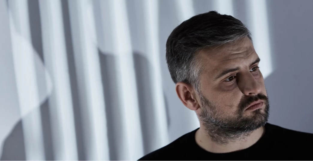 man against a wall with shadows