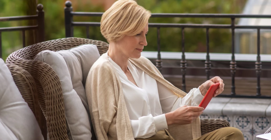 attractive stylish mature woman concentrated on reading a text message