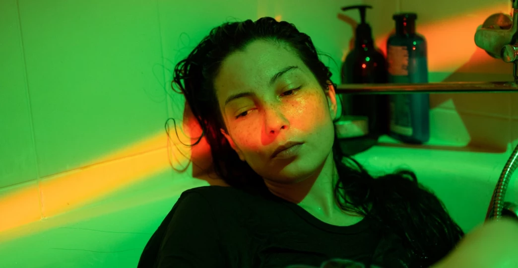 depressed woman with mental disorder apathy anxiety lying in cold bath water dressed in tshirt
