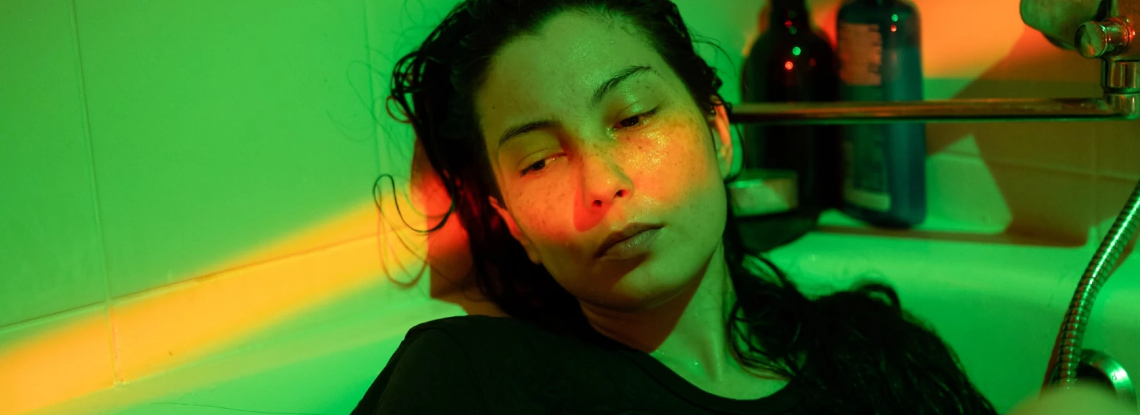 depressed woman with mental disorder apathy anxiety lying in cold bath water dressed in tshirt