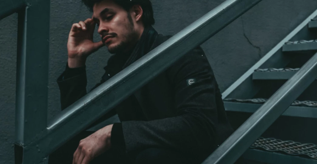 young pensive guy sitting on the stairs