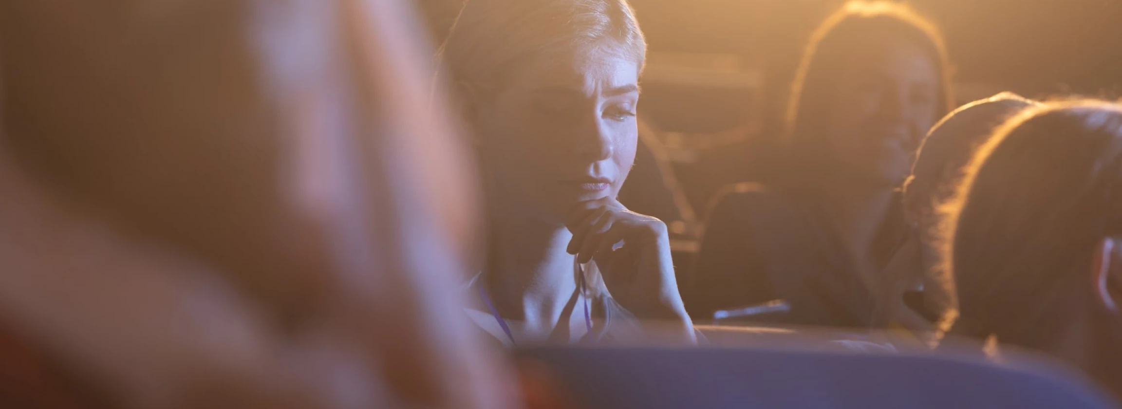 young businesswoman thinking and looking down while sitting in the auditorium