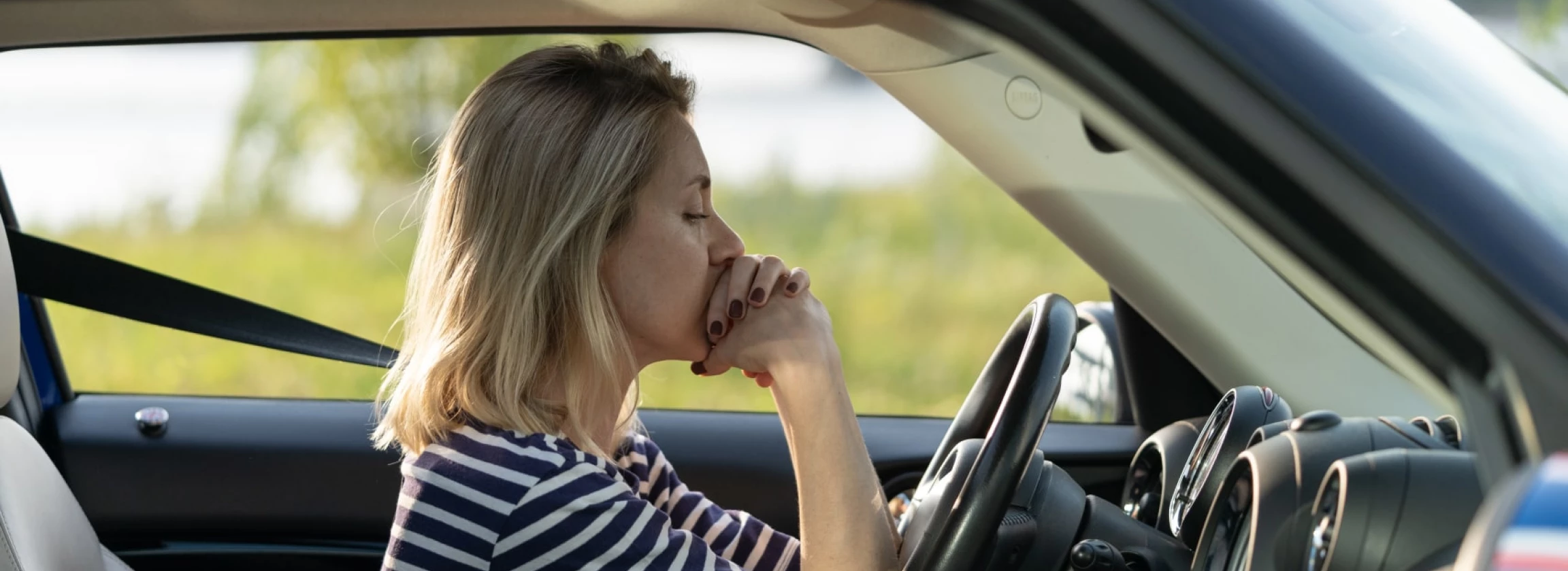 frustrated female driver sit inside car with chin on hands scared to drive