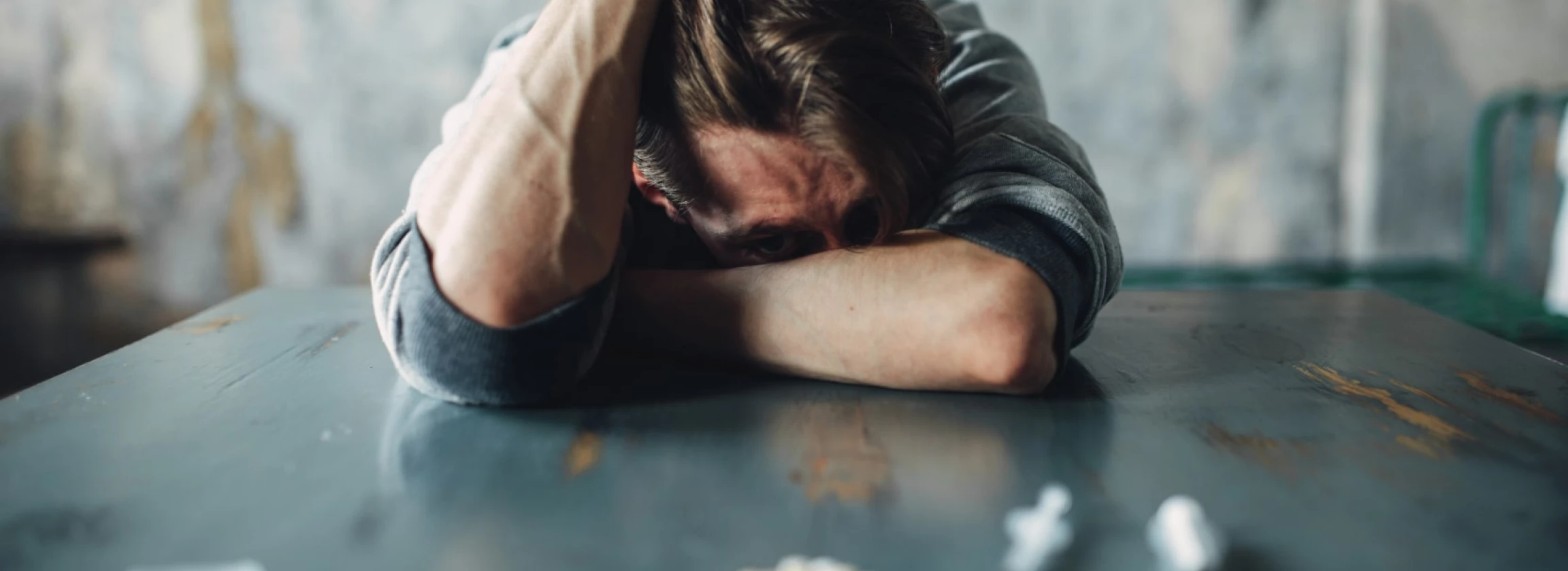 male junkie at the table with drugs and syringe