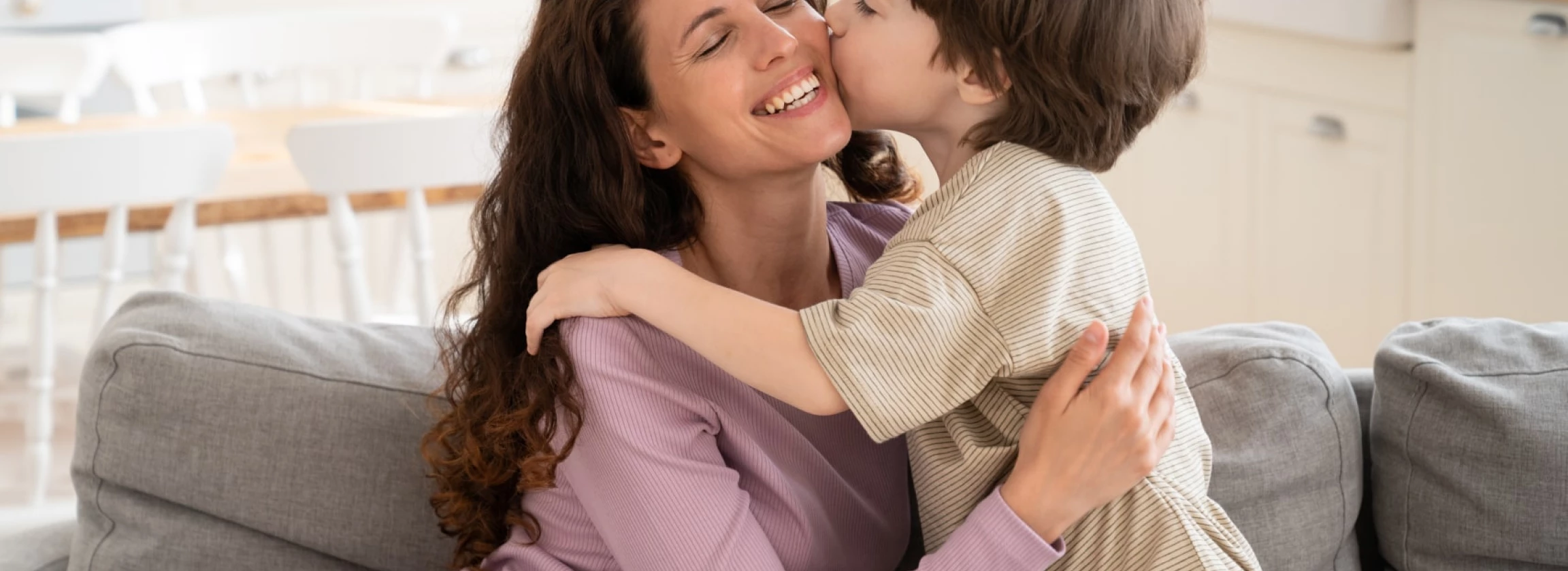 Son boy give mom kiss in cheek embrace single parent mum on mother day
