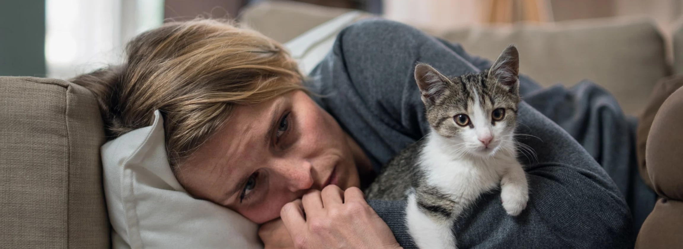 Woman indoors on sofa at home feeling stressed