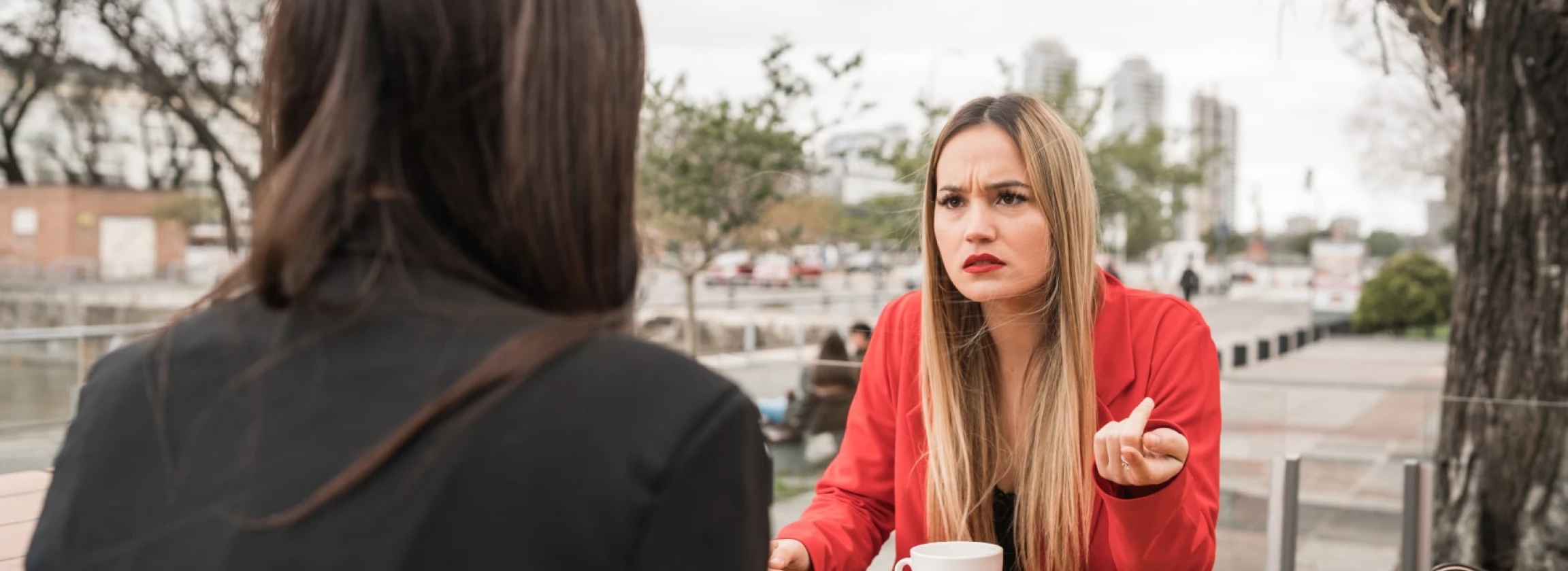 Two angry friends discussing while sitting at coffee shop