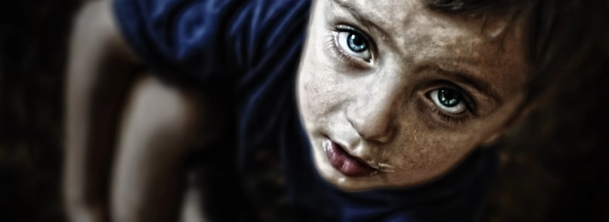 sad looking child portrait on black background