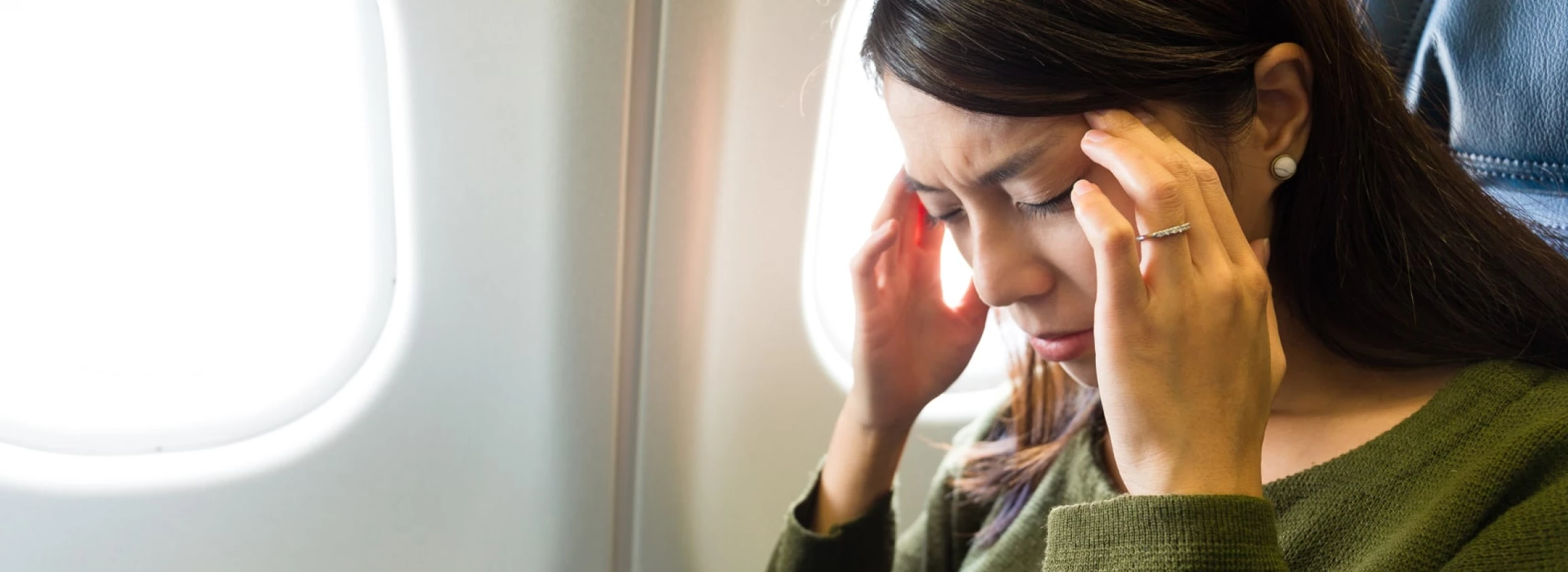 Woman in plane suffer from airsick with stress headache