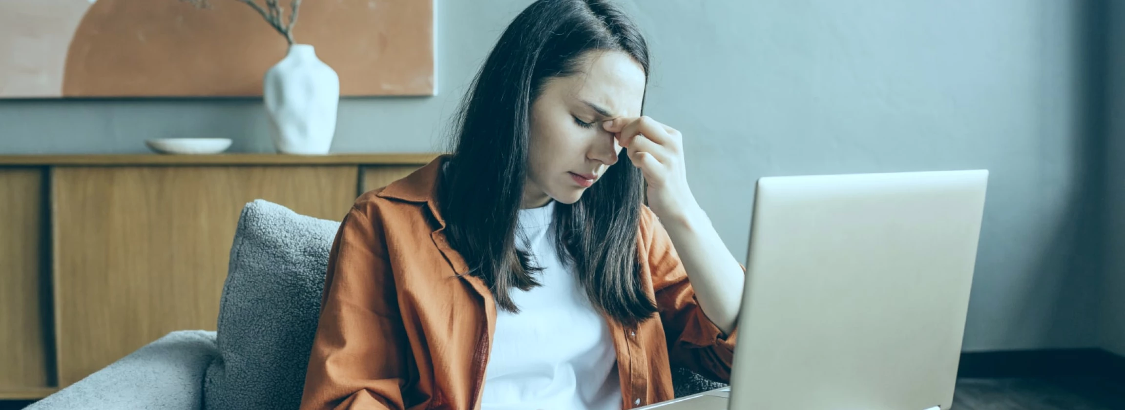 young pretty woman in a state of burnout anxiety working at a laptop