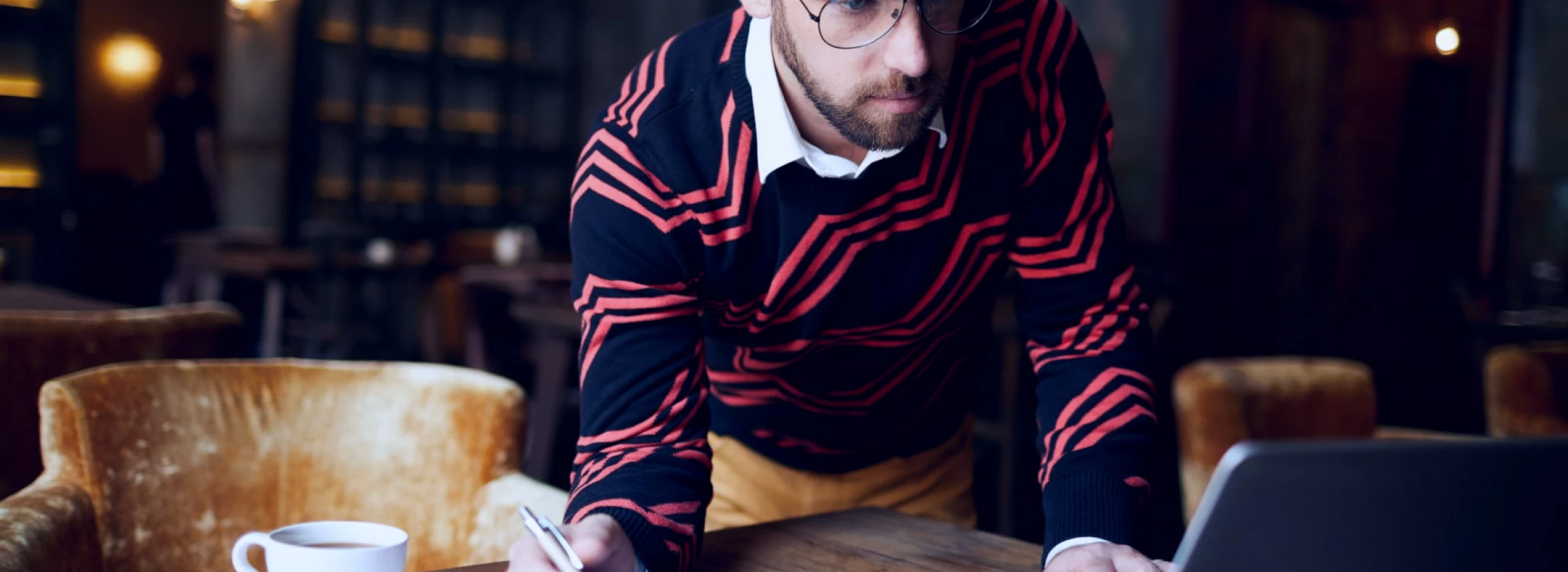 a handsome man taking notes and exploring the internet