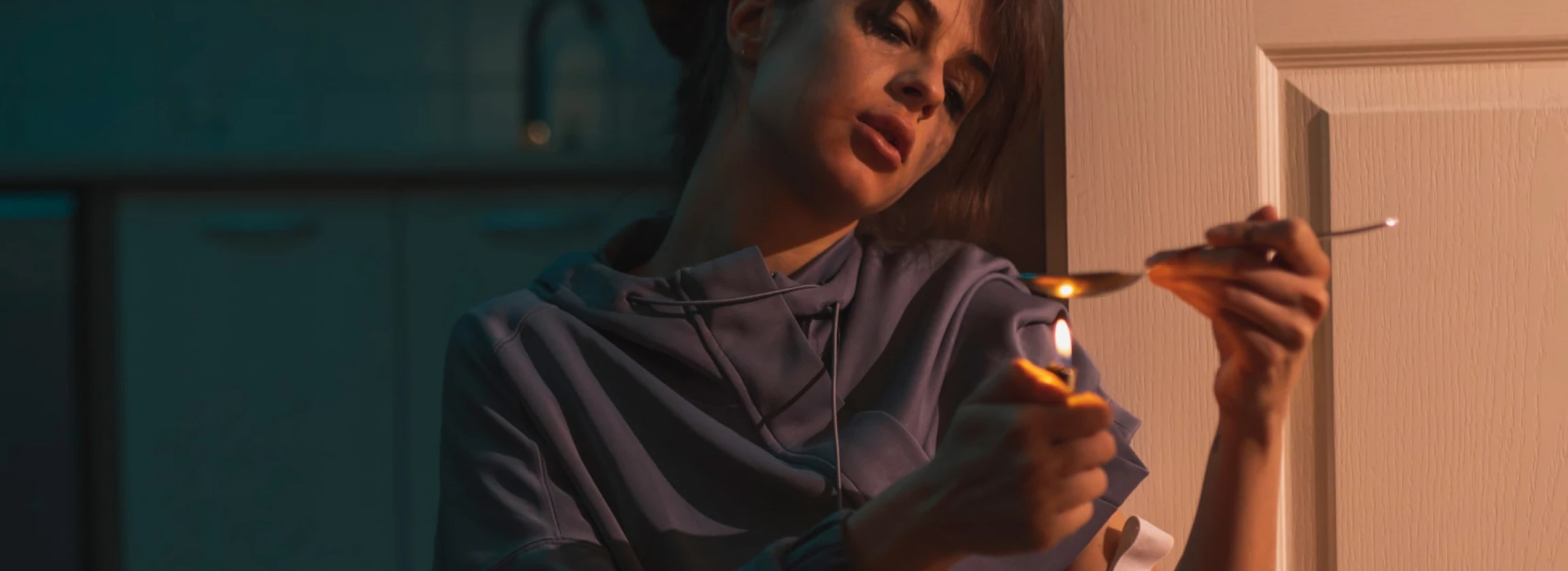 drug addict using lighter and spoon in preparation of intravenous cocaine dose