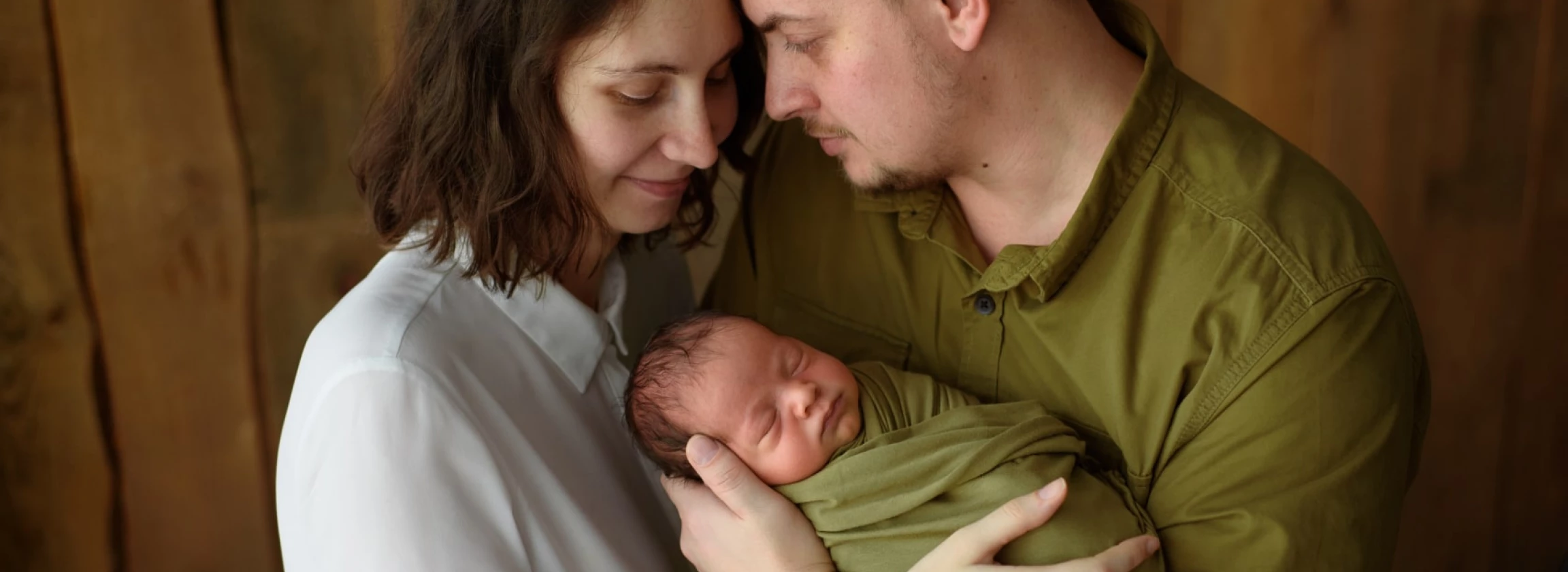 parents hold their newborn son in their arms