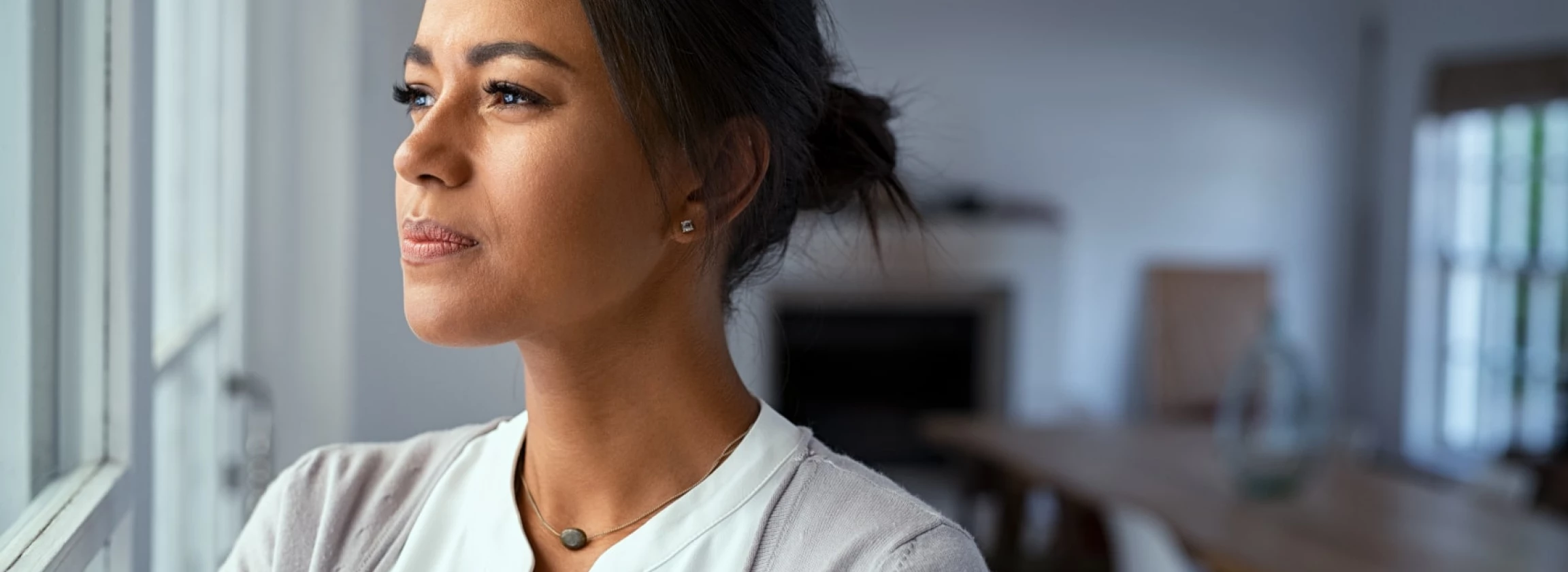 thoughtful black woman looking outside window