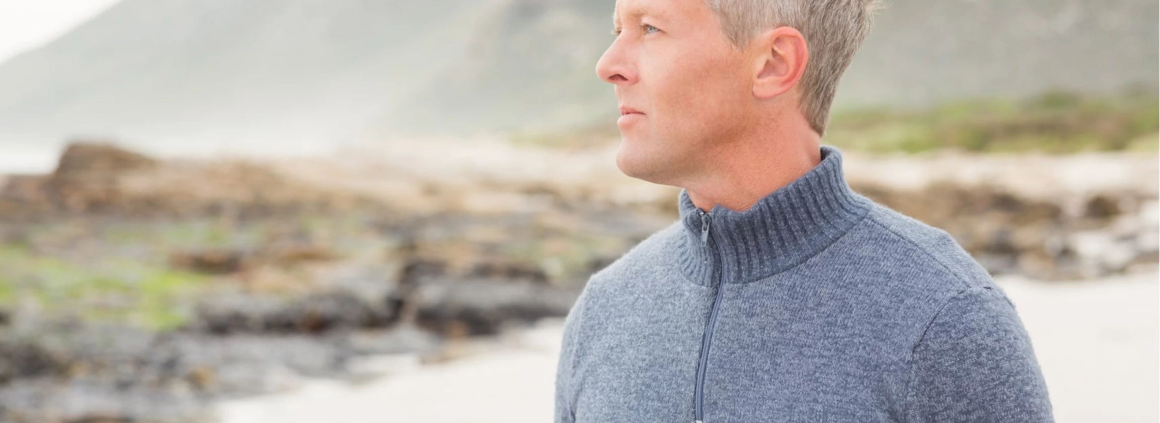 man looking out past the shore of the beach