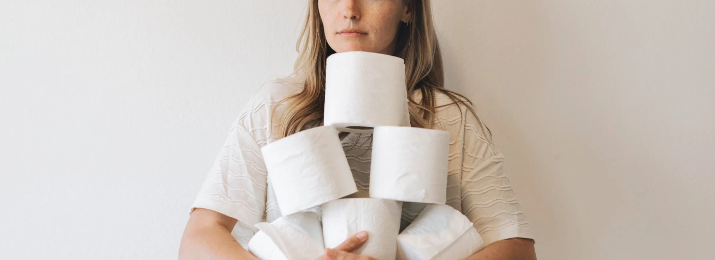 woman with a pile of toilet tissue rolls