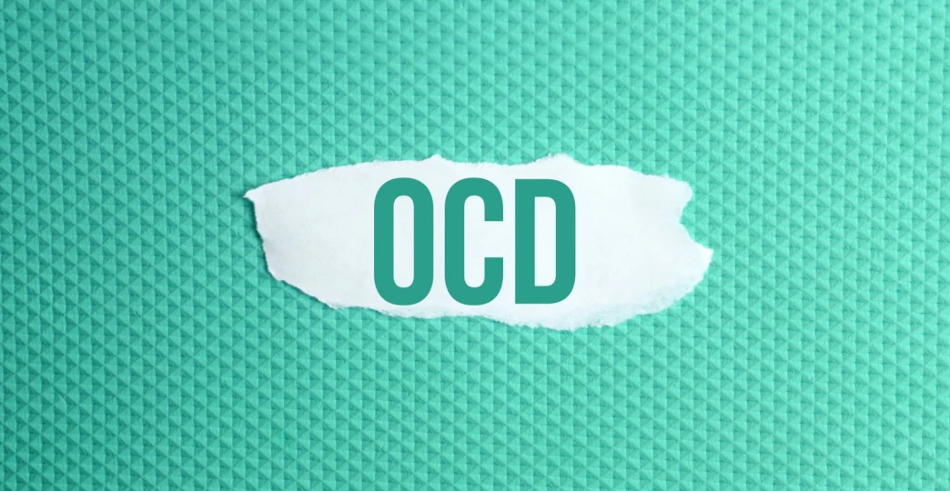 obsessive compulsive disorder a torn paper written with inscription OCD on a green background