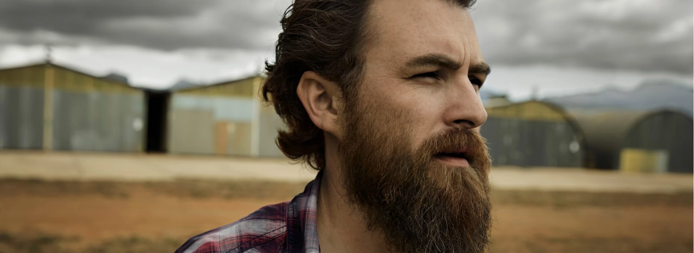 serious man with full beard in abandoned landscape