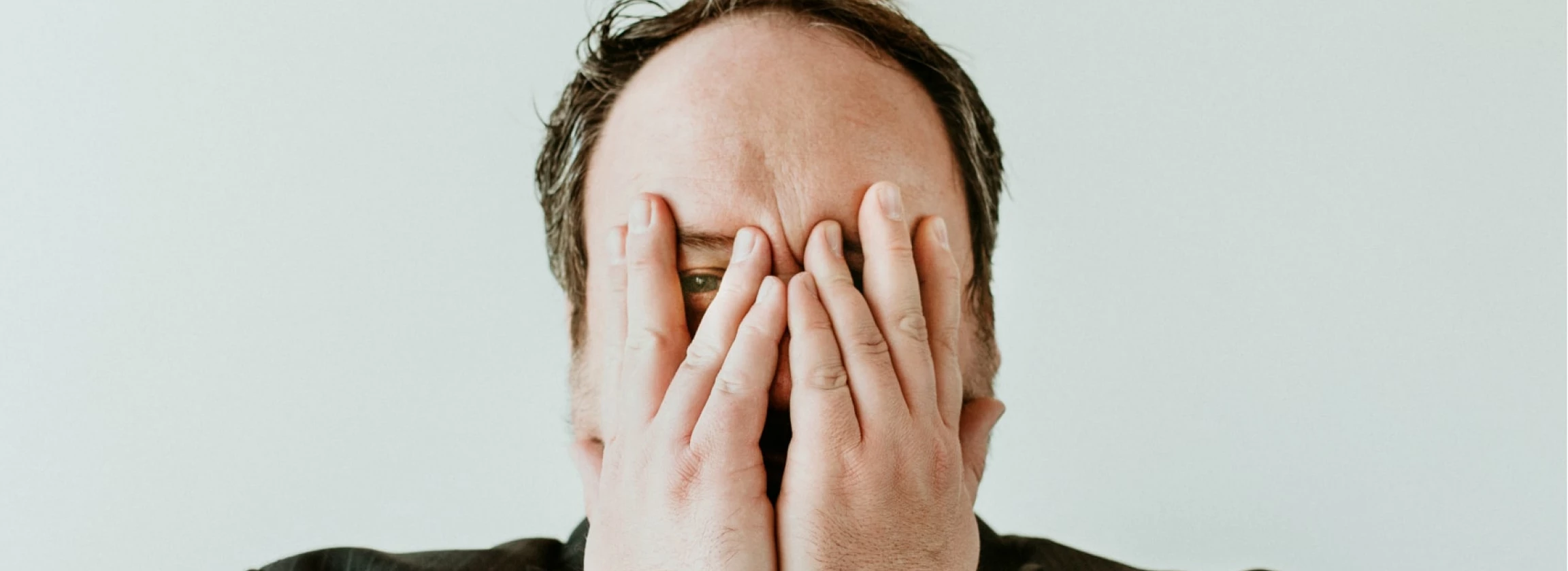 terrify man covering face with his hands