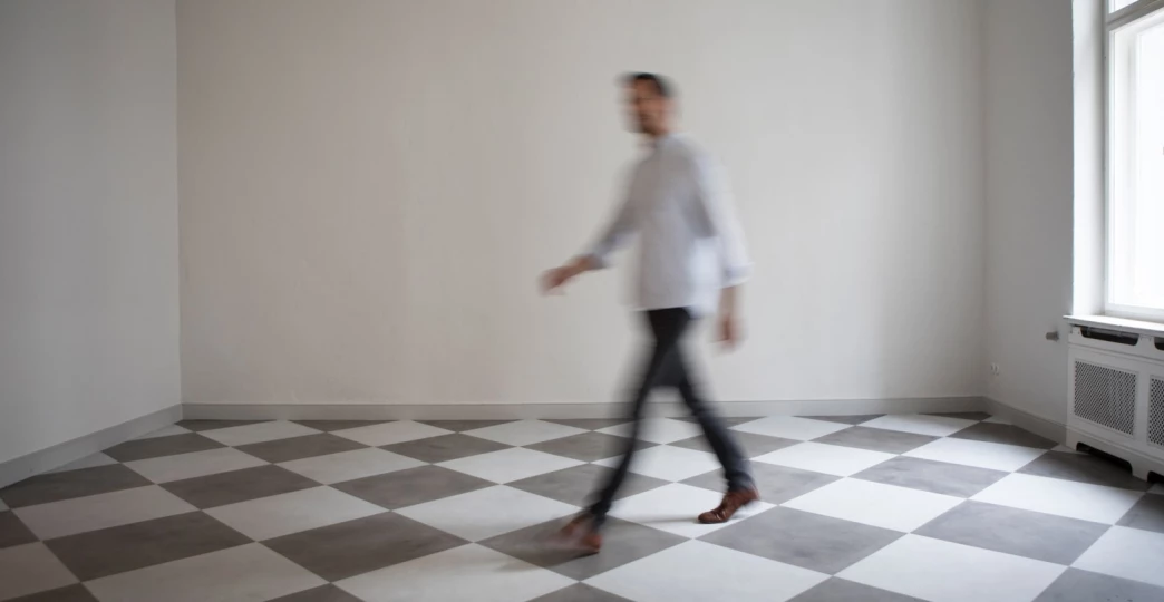 man crossing empty room of an apartment