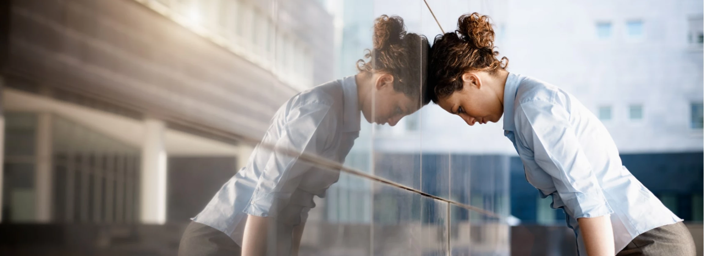 sad business woman banging head against wall
