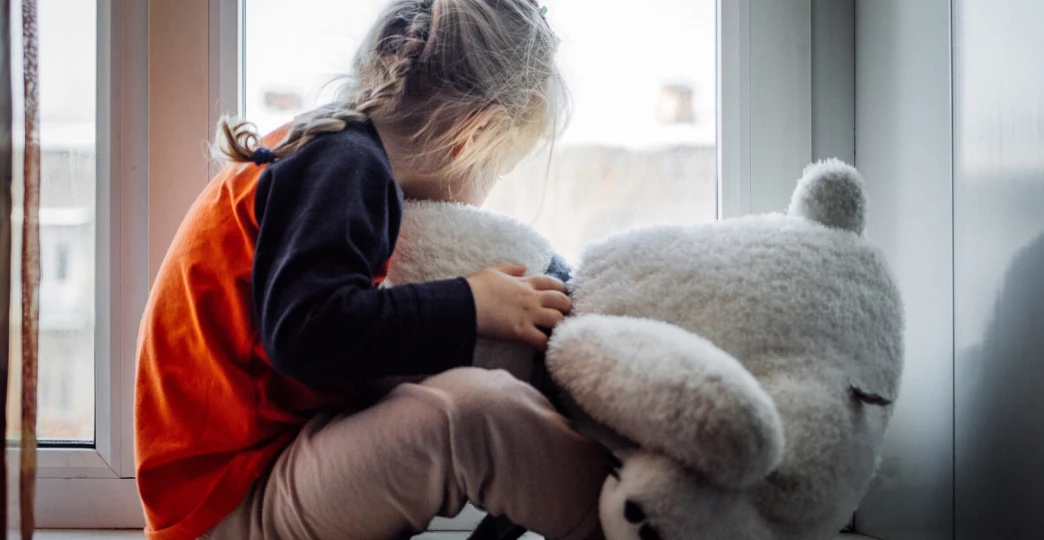 sad little girl with a teddy bear