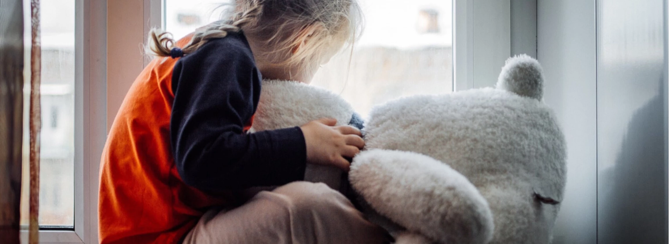 sad little girl with a teddy bear