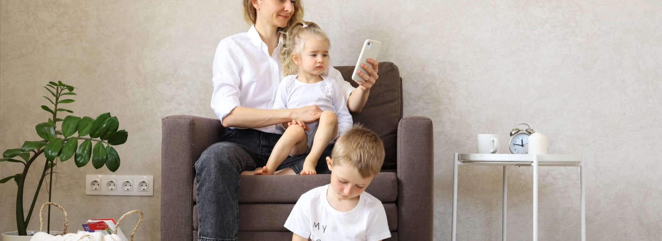 A mother holding a baby and texting