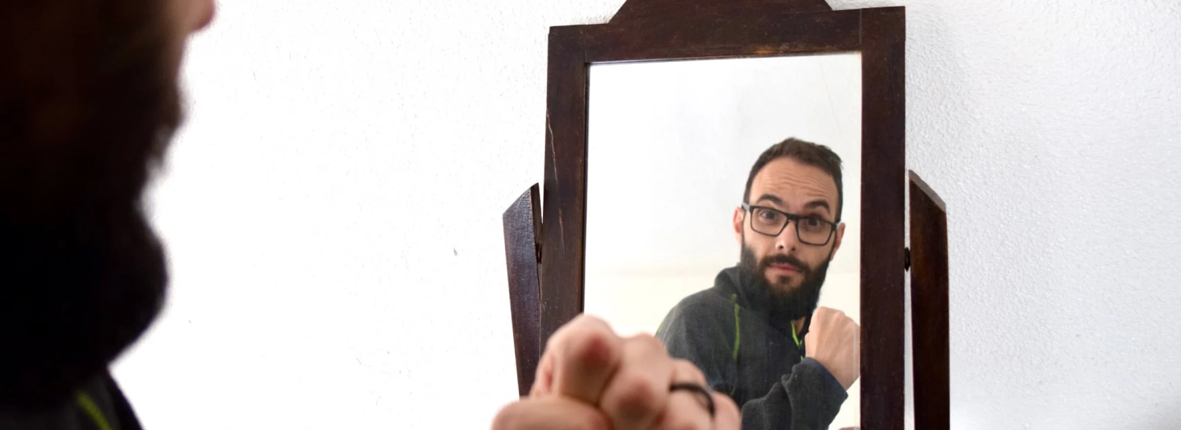 millennial man looking at the mirror and cheering him up narcissistic personality