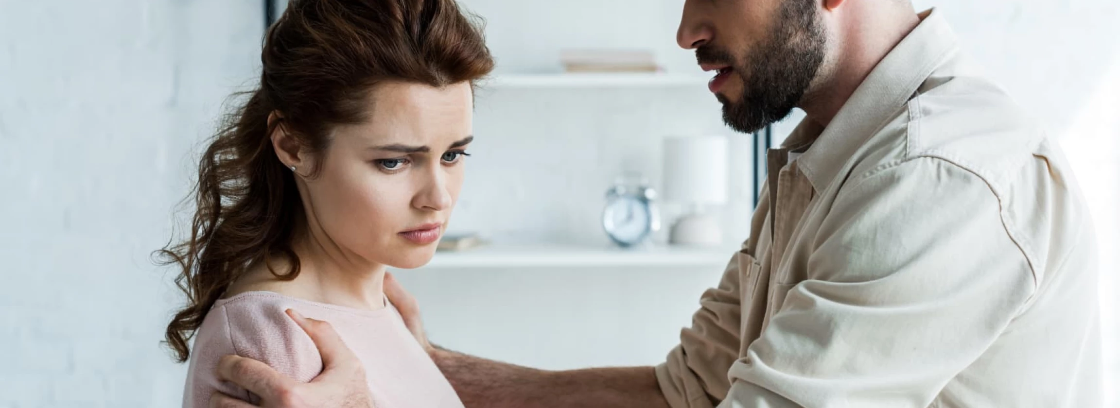 Young man looking angry but not screaming next to a woman who’s also upset