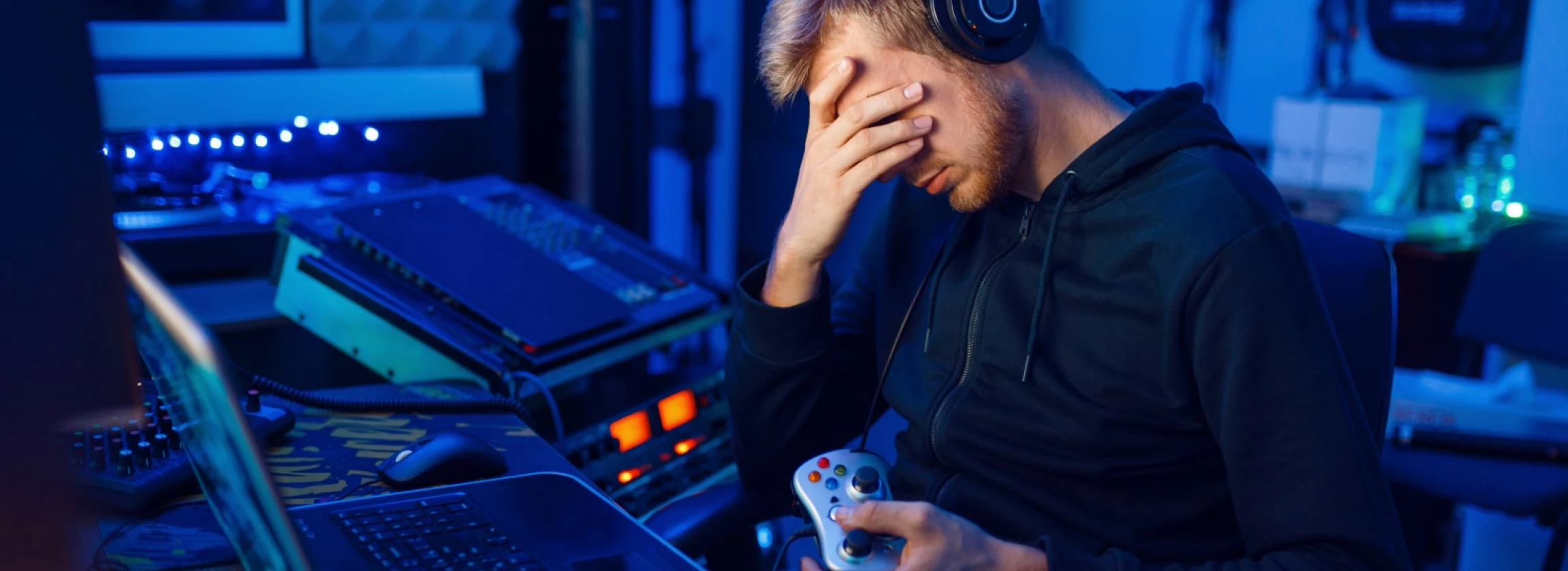 young man sitting at night is tired of his gaming addiction