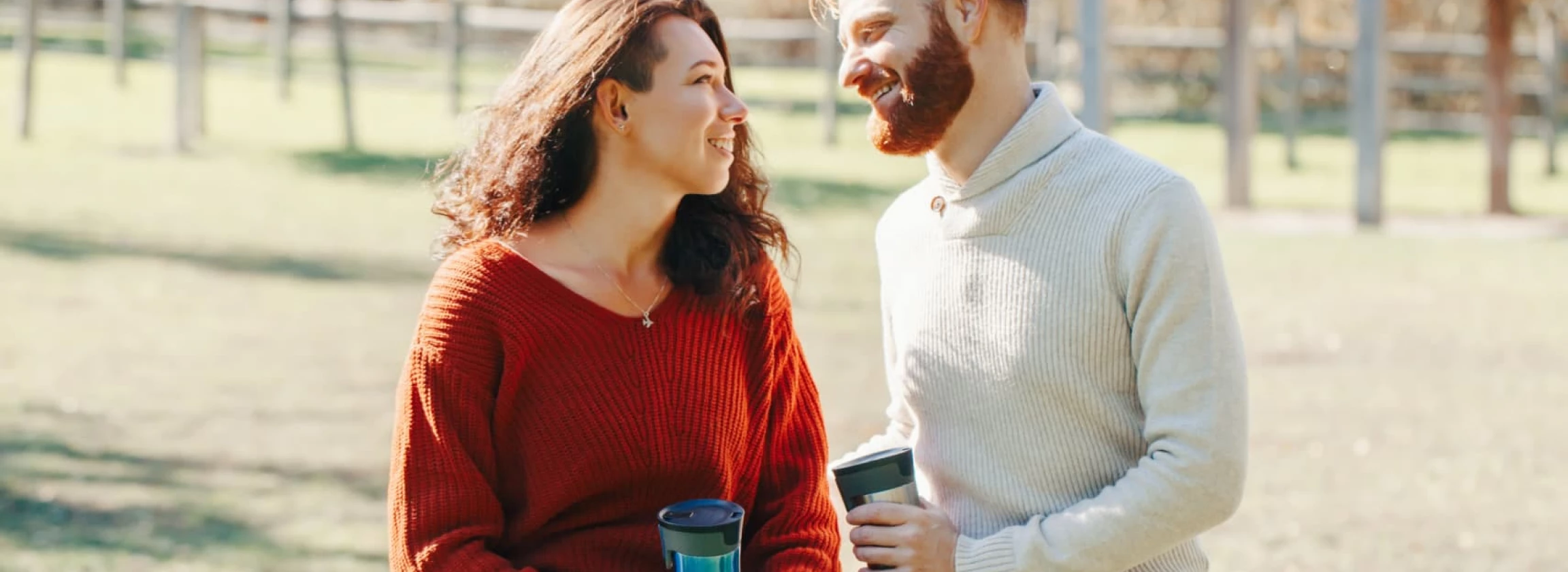 a young couple sits on a fence and enjoys each other's company