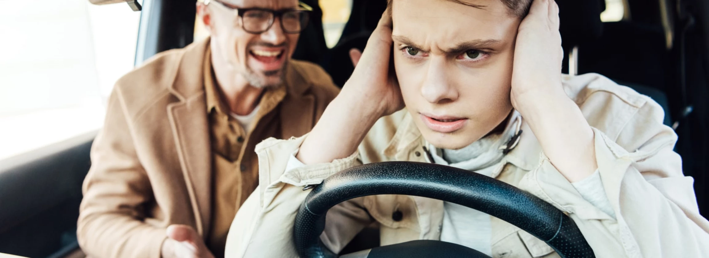 irritated father yelling at teen son in car